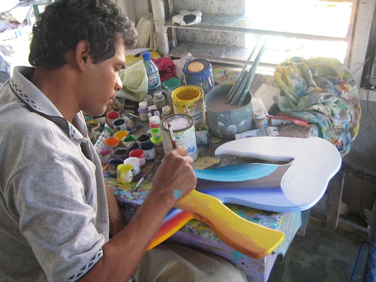 Artist creating colorful wooden fish