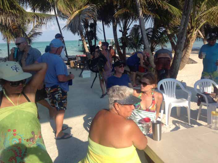 The gang gathers for food and conviviality around the picnic tables on Blackadore Caye.