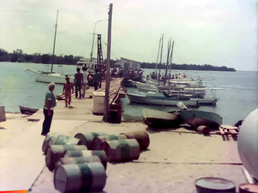 The Placencia pier over the years. One photo showing Eiley family waving goodbye to the Heron H.