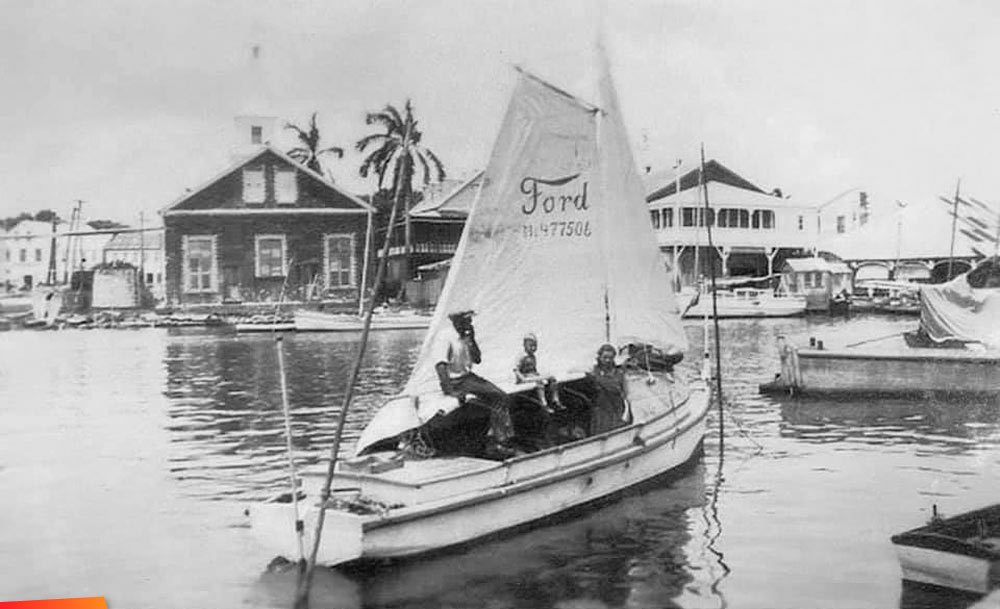 Sailboat with a Ford logo, Belize City about 1925. Looking south, Scots Kirk church in the background, old market far right and Courthouse extreme left 