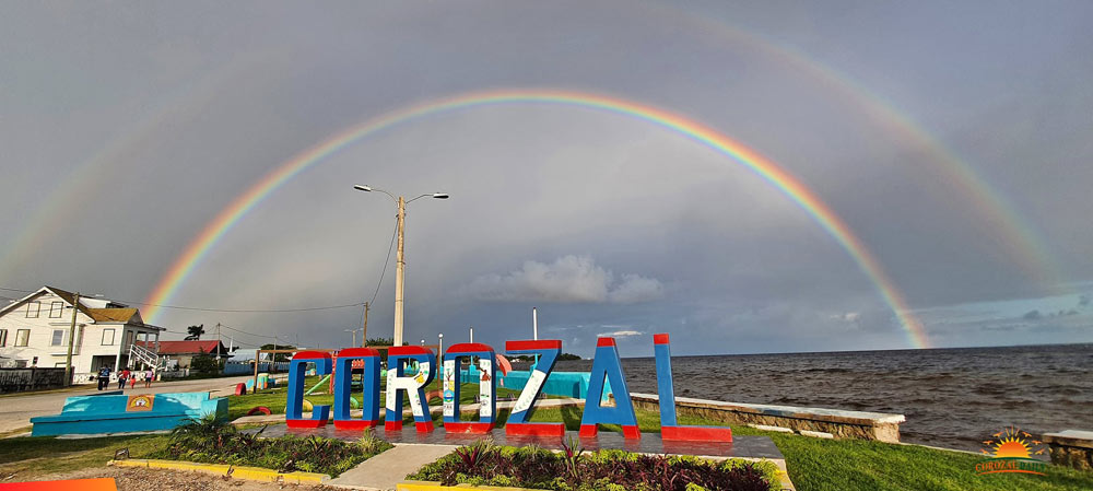 Double rainbow over Corozal Bay with the Corozal sign in the foreground