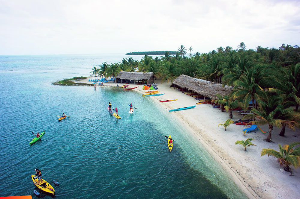 Group fun on the beach with kayaks, Long Caye Beach at Glover's Reef
