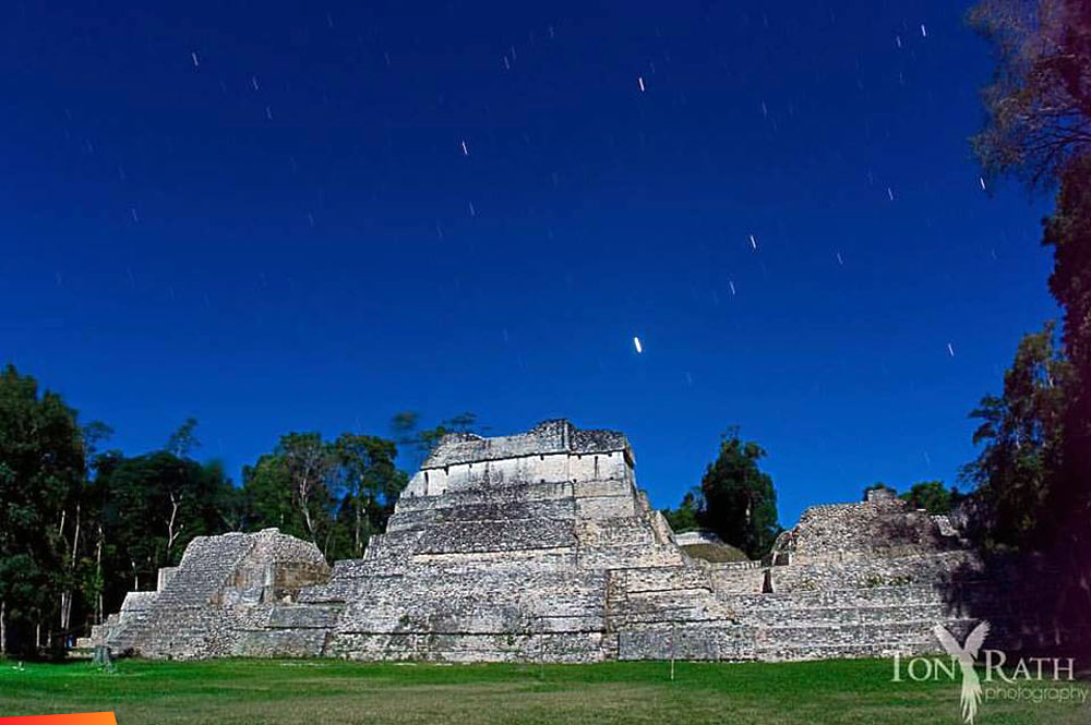 The stars and full moon light over a temple at Caracol Archaeological Park