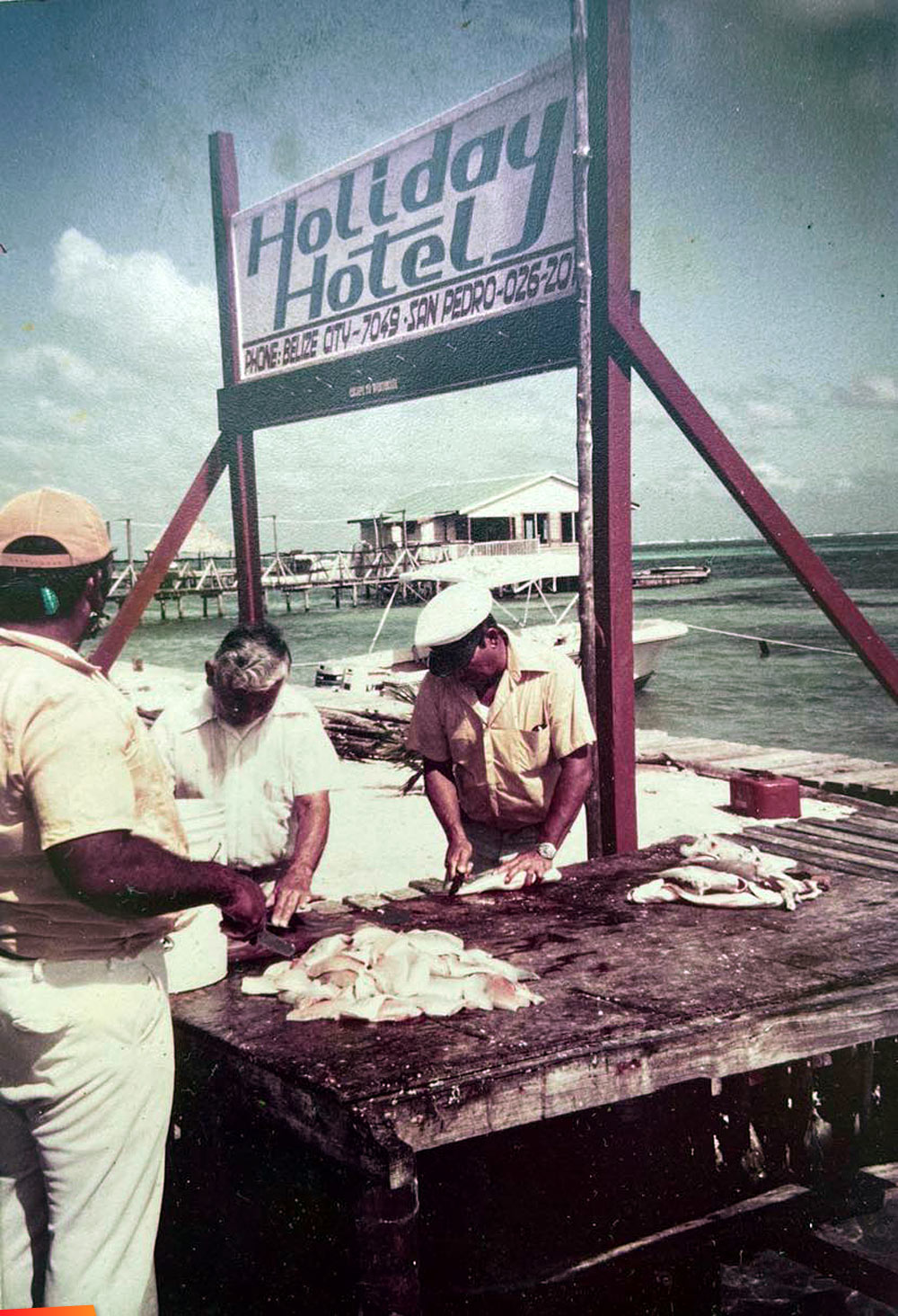 San Pedro fishermen cleaning their catch by the Holiday Hotel, long ago. Manuel Ancona, Eduvijes Ancona, and, Capt. Abel Guerrero