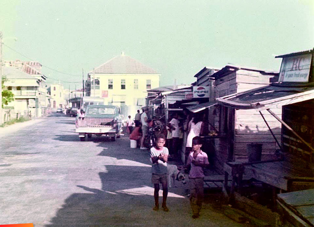 Food, shaved ice, fruit and vegetable stands on North Front Street, an area known as New Market in Belize City, 1975