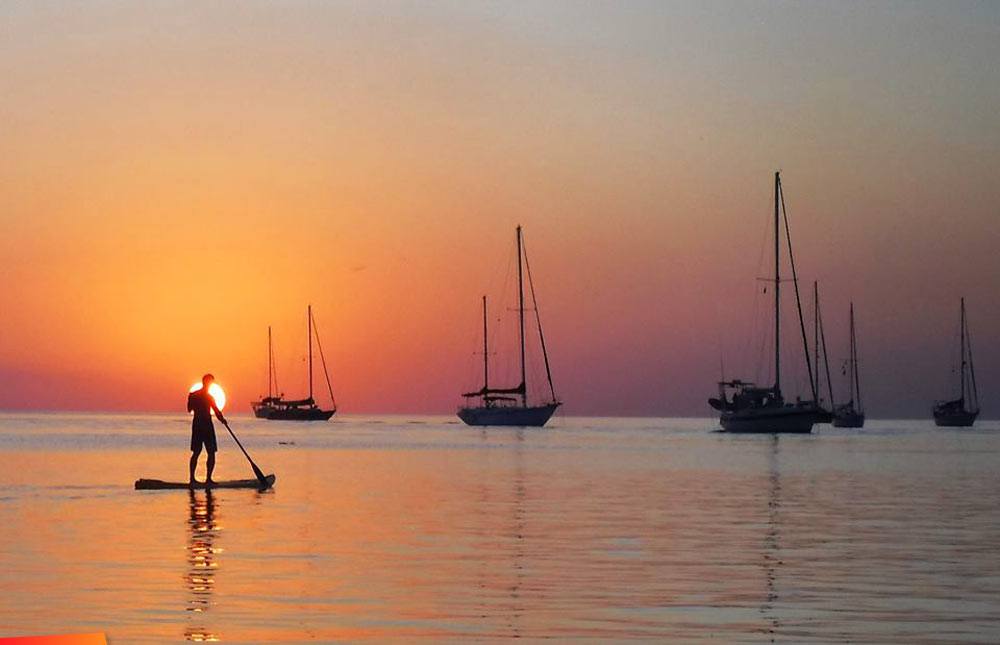 Boats and Stand Up Paddle Board at sunrise off Caye Caulker