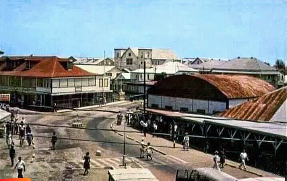 Approach to Swing Bridge from Albert St. Babb Building on the left, Holy Redeemer Cathedral in the middle, the Old Market on the right. Belize City, 1970's