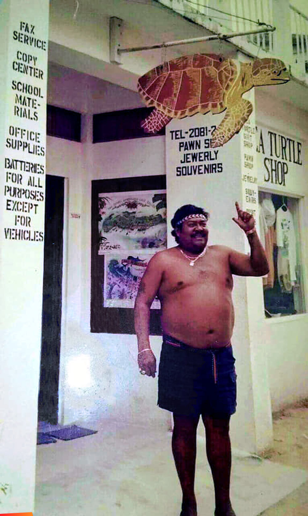 Genaro Nuñez aka Crusher standing outside his Sea Turtle Gift Shop in San Pedro on Pescador Drive, long ago