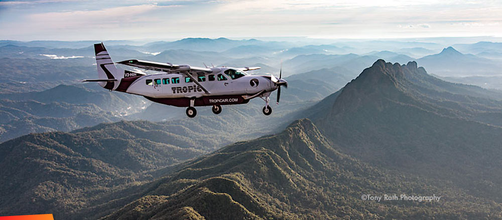 A Tropic Air plane flying over the Cockscomb Range in Southern Belize with Victoria Peak in the background