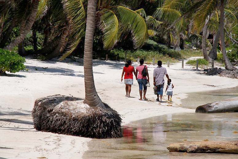 Family walking along the shore on north Ambergris Caye