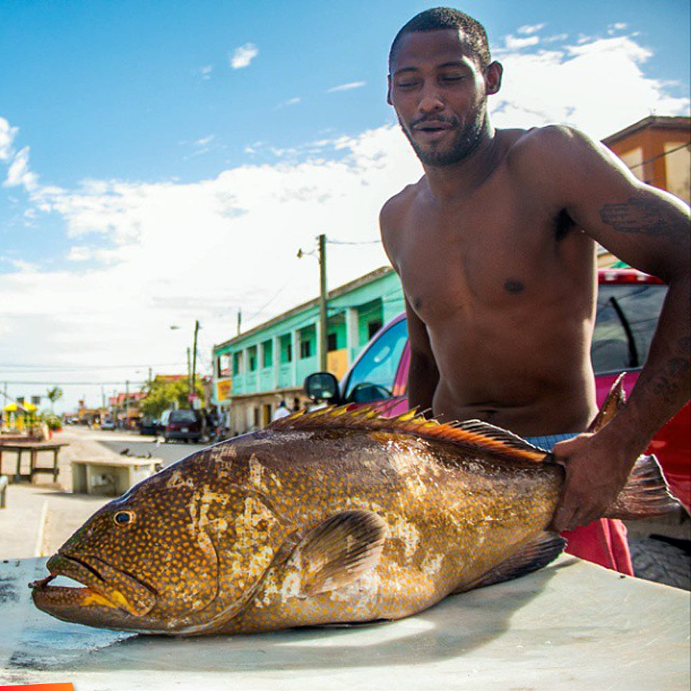 Fisherman proudly shows his catch at the usually busy Conch Shell Bay fish market in Belize City