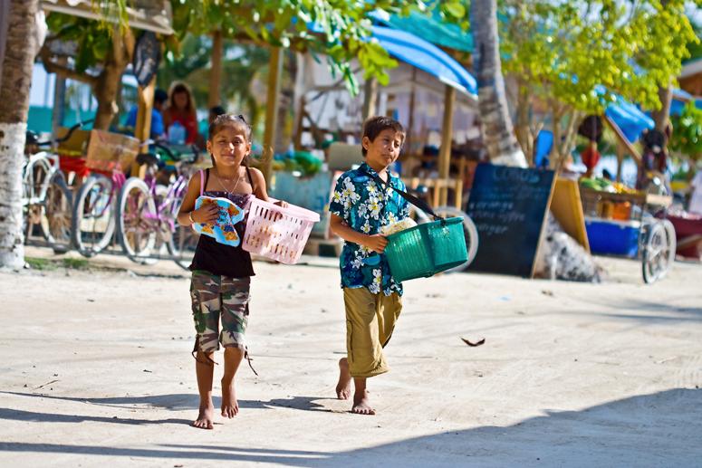 Children selling coconut fudge on the beach on Caye Caulker