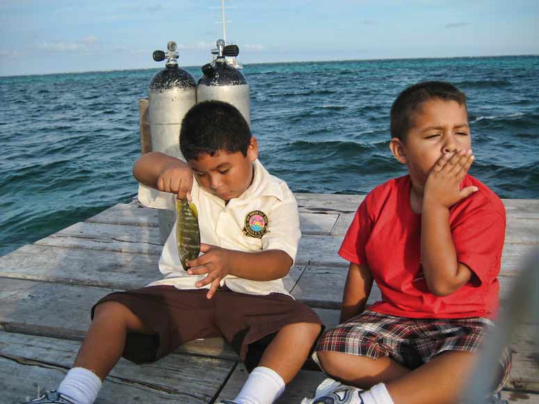 Two Marin boys examining the fish their father caught
