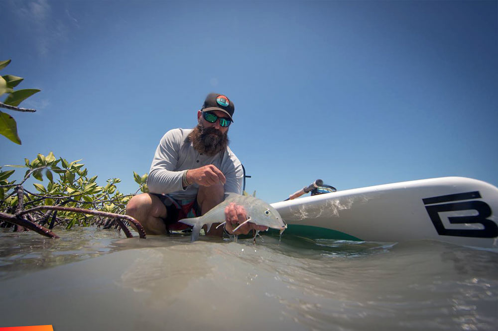 Catching a bonefish on a paddleboard at Cayo Frances Farm and Fly on Ambergris Caye